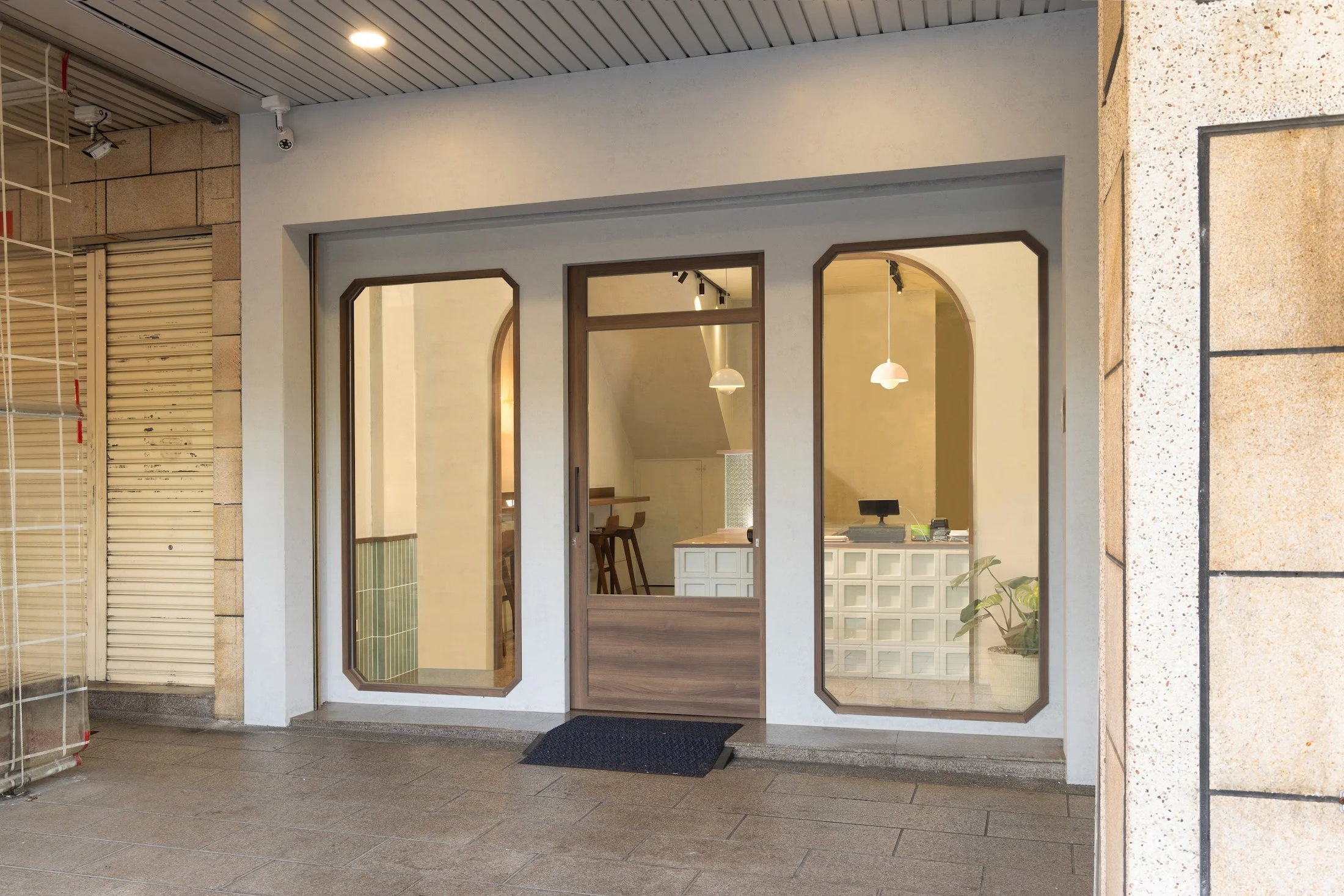 台中北屯健康餐盒門市入口，切角玻璃窗與深木色門框